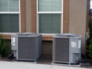 Two ACs installed outside the house near the window with louvres.