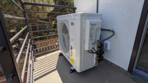 Corner view on a Mini Split Air Conditioner outside unit installed by Accord Air in San Diego with all the tubes and wires.