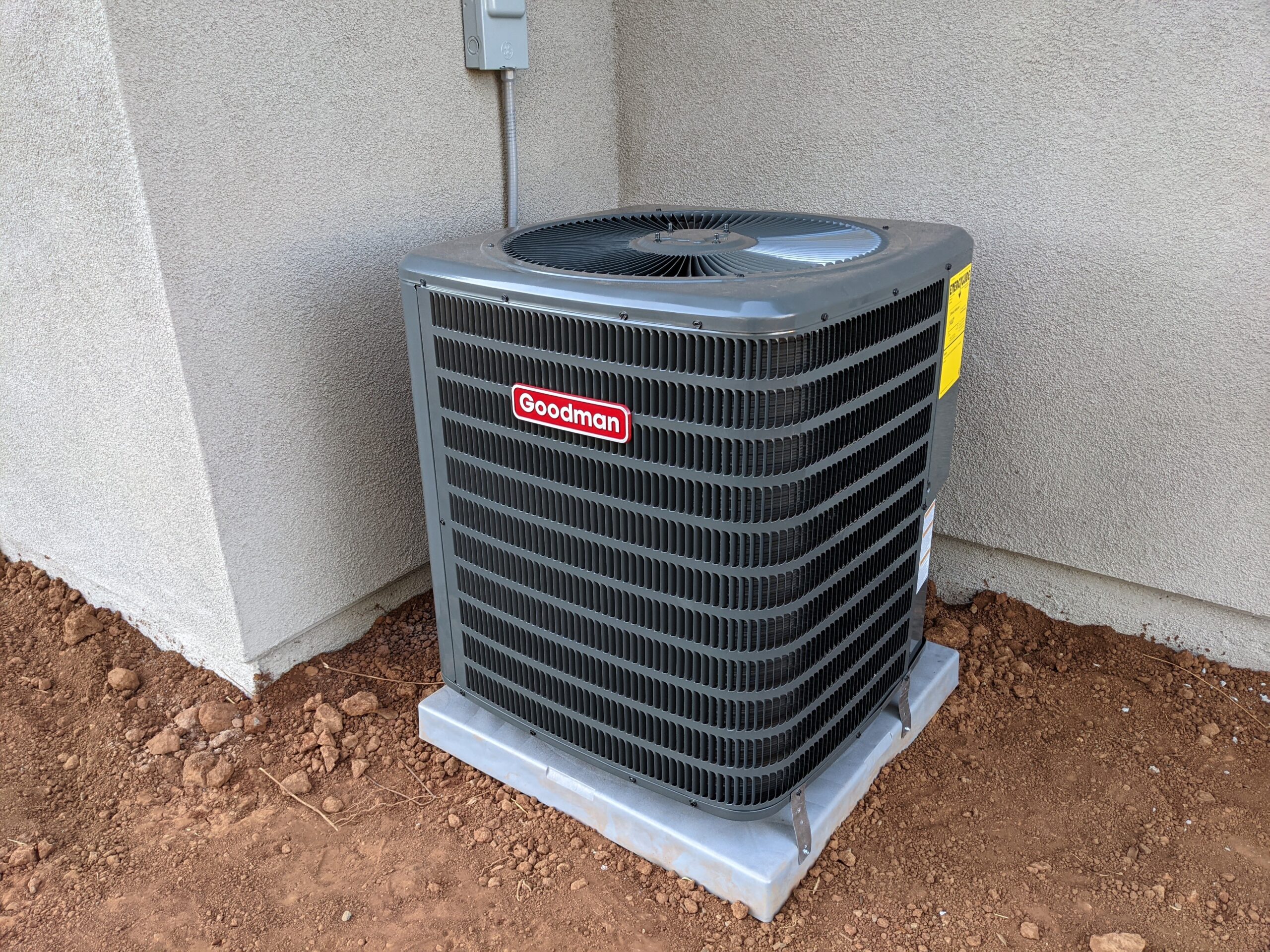 Goodman AC installed in a corner on the exterior of the building.