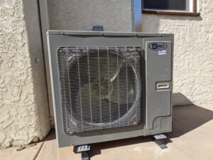 AC PRO air condition outdoor unit installed in a corner on the outside of the building.